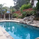 Swimming pool with stone landscaping and a raised water feature